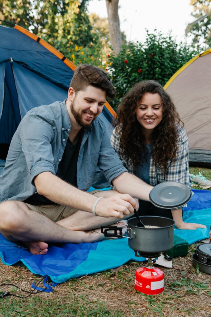 Man and Woman Cooking Near the Tents